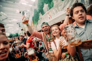 慕尼黑ESN Oktoberfest Campsite的一群人在酒吧喝啤酒欢呼