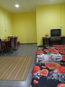 巴西富地Hotel Murah Pasir Puteh的客房设有两张床、一台电视和一张桌子。