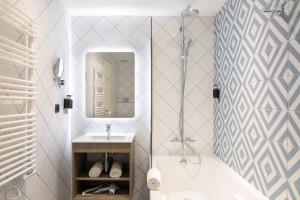 尼斯 快乐文化德克酒店的带浴缸、水槽和镜子的浴室