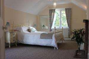 科尔福德Silhouette Cottage的卧室配有白色的床和窗户。