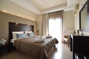 乐托卡亚Hotel Dionisos的一间设有大床和窗户的酒店客房