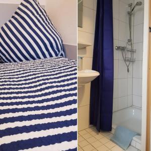 赫尔博恩Hotel Garni的一间带蓝白条纹枕头的卧室和一间浴室