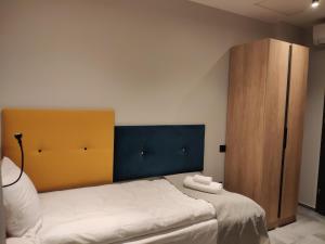 比托姆H33 Apartamenty的一间卧室配有一张床和一个木制橱柜