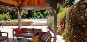 沙托沙隆拉图尔查理曼塔旅馆的一个带沙发的庭院,位于泳池旁的凉棚下