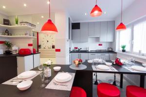 毛科Flame Luxus Apartman的厨房配有餐桌和红色椅子