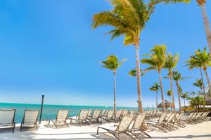 雷顿Fiesta Key RV Resort Standard ADA Room 5的棕榈树海滩上的一排椅子