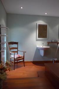 VinzellesLe Lavoir de Meziat的一间带椅子和水槽的浴室