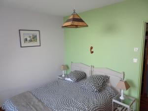卡朗泰克Roch'ar piguet的一间卧室配有带两个枕头和一盏灯的床