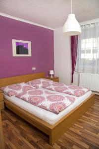 塔亚河畔拉镇Appartementhaus Thermeneck的一间卧室配有一张紫色墙壁的床