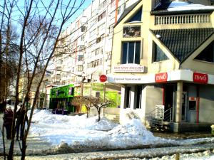 尼古拉耶夫НЕБОЛЬШАЯ СТУДИЯ проспект Центральный 124А WI-FI 2 дивана 3 этаж 9 этажного дома的大楼前有雪覆盖的街道