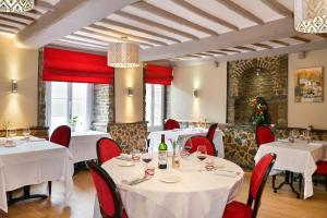 克莱西赛特诺曼德之家酒店的一间设有白色桌子和红色椅子的餐厅