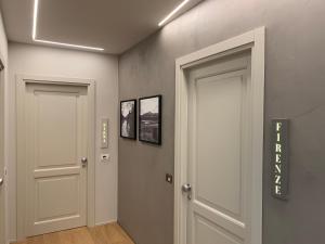 蒙特瓦尔基Palazzo Vasarri - Luxury design suites的走廊上设有两扇门,墙上有两张照片