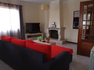 圣玛丽亚大德费拉Apartamento Arosa的客厅设有红色的沙发和壁炉