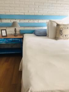 埃斯特角城Blu Inn的一间卧室配有一张白色的床和蓝色床头板
