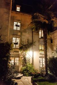 贝叶Manoir Sainte Victoire的前面有棕榈树的建筑