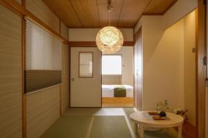 大阪Bijou Suites Will的走廊上设有门、桌子和床