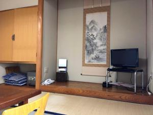 上田市Saihokuso inn的客厅配有木桌上的电视