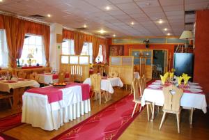 布拉迪斯拉发多米尼卡酒店的一间设有桌椅的用餐室,配有白色和红色的桌子