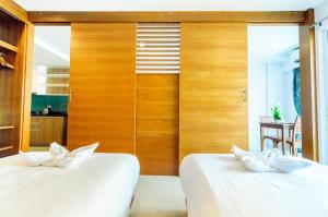 南芭堤雅格居公寓式酒店的木墙客房的两张床