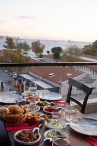 伊斯坦布尔Meydan Besiktas Hotel的阳台上摆放着食物盘的桌子