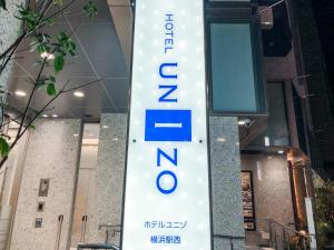 横滨UNIZO酒店 - 横滨站西(HOTEL UNIZO Yokohamaeki-West)的大楼前的酒店标志