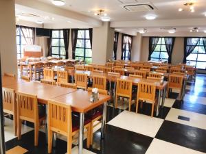 鹿儿岛凯莎芭鹿儿岛第一酒店的一个带桌椅的教室,位于带窗户的房间