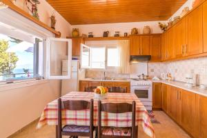 盖奥斯Casa Soula, Gaios Seaview Cottage的厨房配有桌椅和窗户。