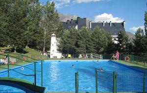福米加尔Ski & relax Apartment的一座位于公园内的大型游泳池,公园内有一座城堡