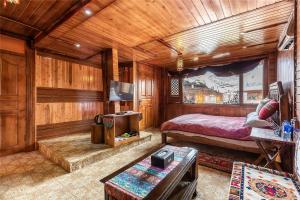 香格里拉艺栈藏式精品客栈的一间卧室配有一张床和一台电视。