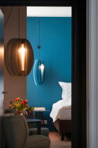 布鲁日Zakske13 - Design Boutique B&B in Bruges city centre的卧室拥有蓝色的墙壁,配有一张床和椅子