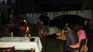 阿努拉德普勒Aura City Hostel的一群人晚上坐在桌子上