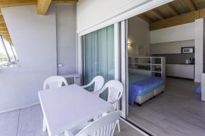 比比翁Residenza Turistica Alberghiera Blue Marine的配有白色桌子、椅子和床的房间