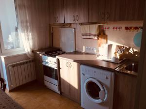 蒂拉斯波尔Clean apartment on Lunacharskogo street的厨房配有洗衣机、炉灶和水槽。