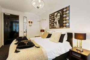 Eefde阿丽萨别墅哈尔尼酒店的卧室配有一张白色大床,墙上挂有绘画作品