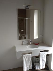 卡萨拉雷纳Hotel Entrerailes的白色的浴室设有水槽和镜子