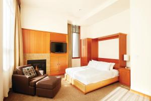 惠斯勒惠斯勒泛太平洋度假村的一间卧室配有一张床、一把椅子和电视。