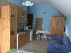 比克Villa Bella Apartman的厨房配有木制橱柜和桌椅