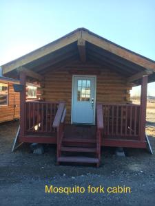 Clear Creek ParkAlaska Log Cabins on the Pond的小木屋设有门廊和门