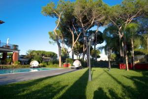SelcettaRelais Villa Italia的一个带游泳池、树木和街灯的庭院