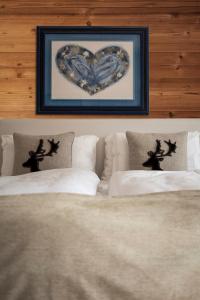 圣维托-迪卡多雷FIORI Dolomites Experience Hotel的卧室内两张床上的心影