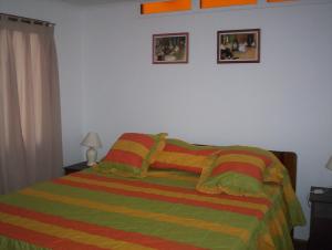 科金博cabañas sector peñuelas的卧室配有一张床,墙上挂有两张照片