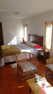 科金博cabañas sector peñuelas的一间卧室配有两张床、一把椅子和一张桌子