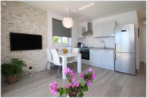 罗戈兹尼察Apartments Silver Beauty的厨房配有白色桌子和白色冰箱。