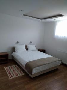 维尔蒂尼克Simića ćoše的一间卧室配有一张带白色床单的床和一扇窗户。