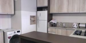 本图贡萨尔维斯Apto prox. BR470的厨房配有白色冰箱和木制橱柜。