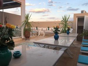 马拉喀什BED SQUARE Hostel的阳台的天井配有桌子和盆栽植物