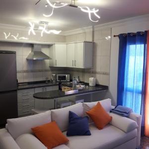 阿里纳加Vivienda FRALEMAR Arinaga.的客厅配有白色沙发,提供橙色和蓝色枕头