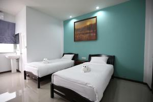 清莱SABUN-NGA HOSTEL的蓝色墙壁客房的两张床