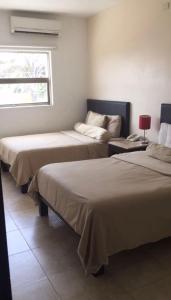 比亚埃尔莫萨Suites Real Tabasco的客房设有两张床和窗户。