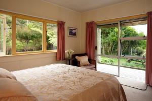 科灵伍德Te Hapu Coastal Cottages的一间卧室设有一张床和一个大窗户